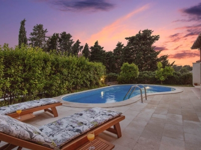 Deck chairs and pool at dusk